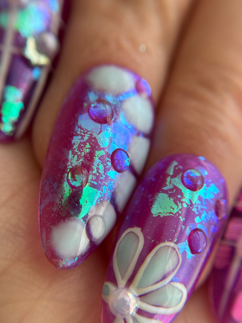 Violet Reverie purple iridescent handmade press-on nails with floral art and crystal details worn on hand