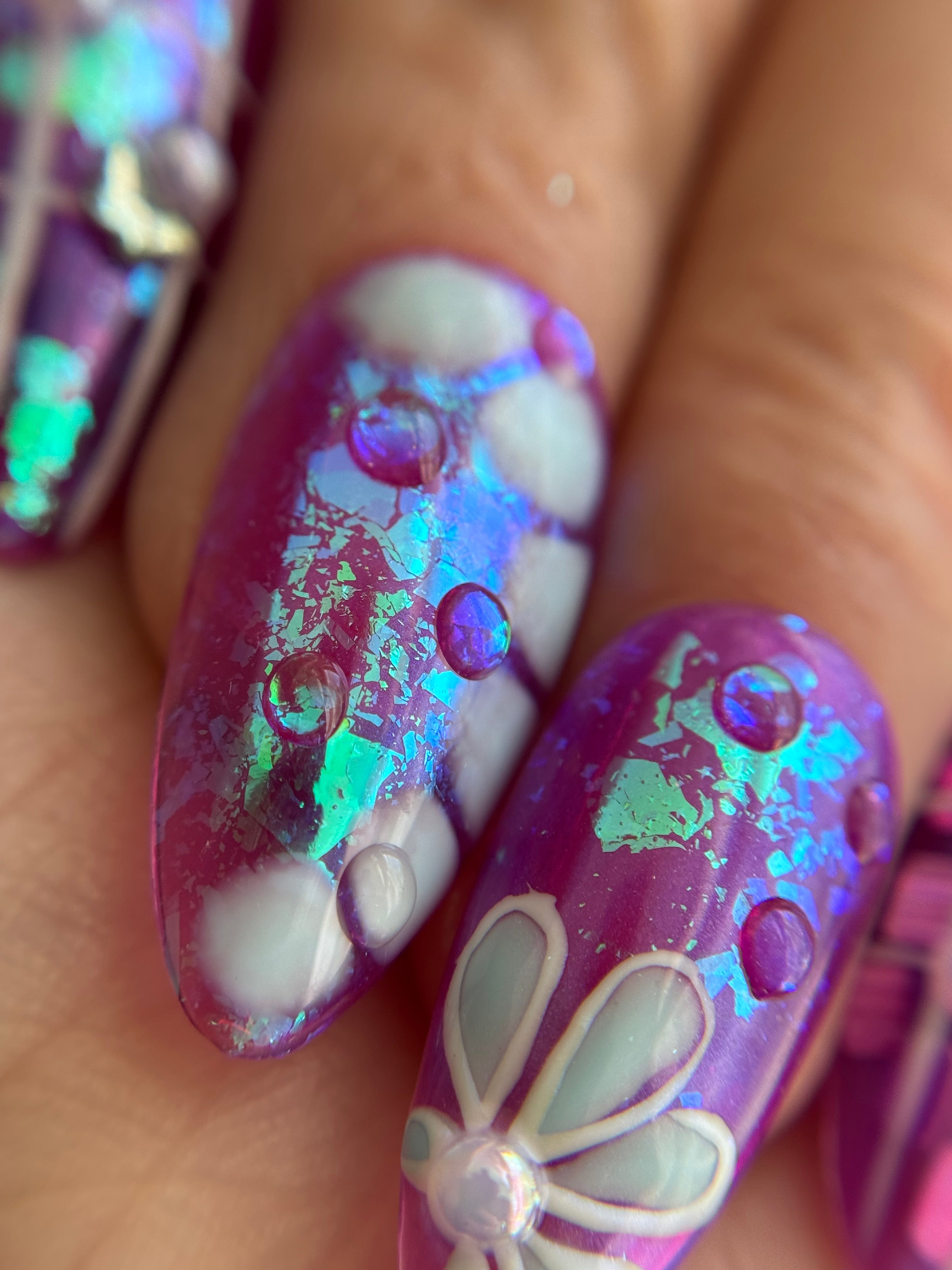 Violet Reverie purple iridescent handmade press-on nails with floral art and crystal details worn on hand