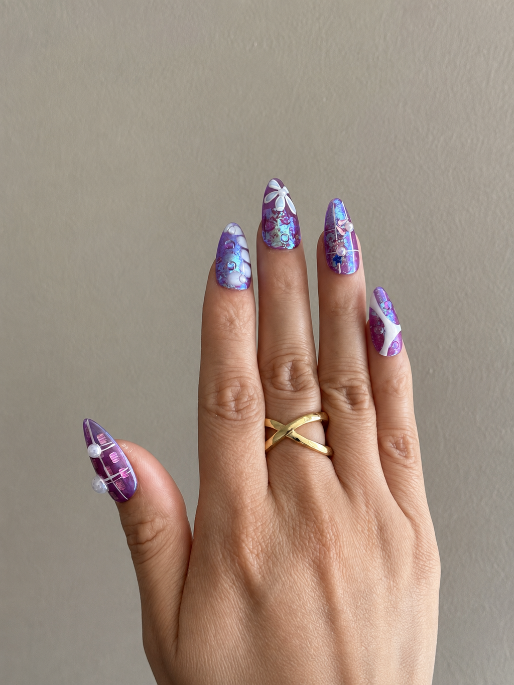 Violet Reverie purple iridescent handmade press-on nails with floral art and crystal details worn on hand
