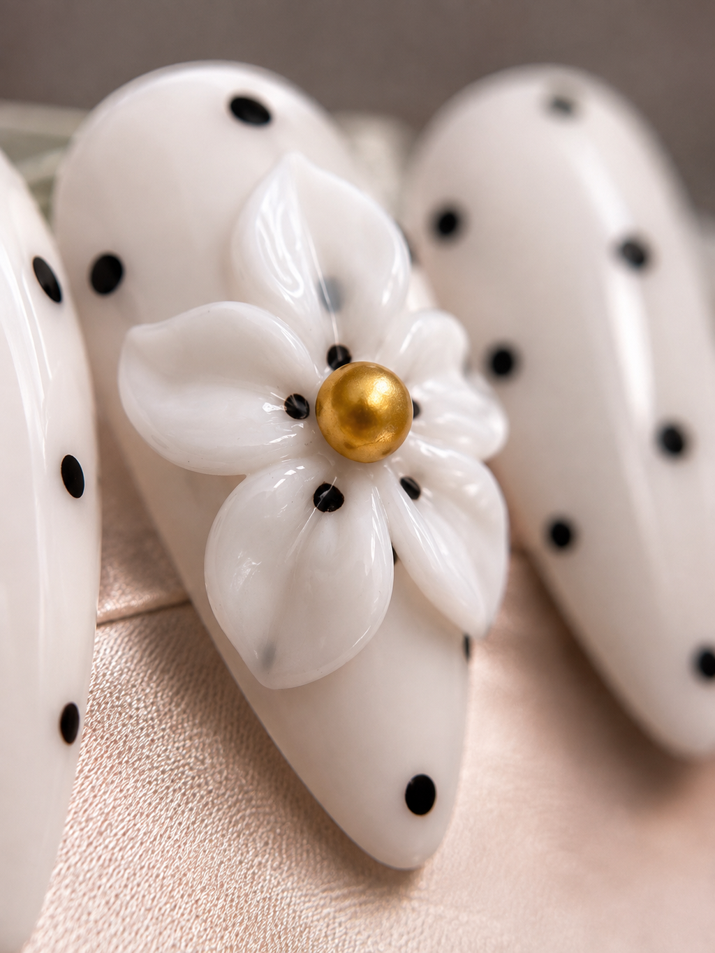  Close-up of Daisy Noir glossy almond press-on nails.
