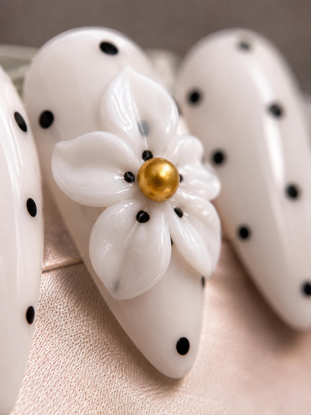  Close-up of Daisy Noir glossy almond press-on nails.