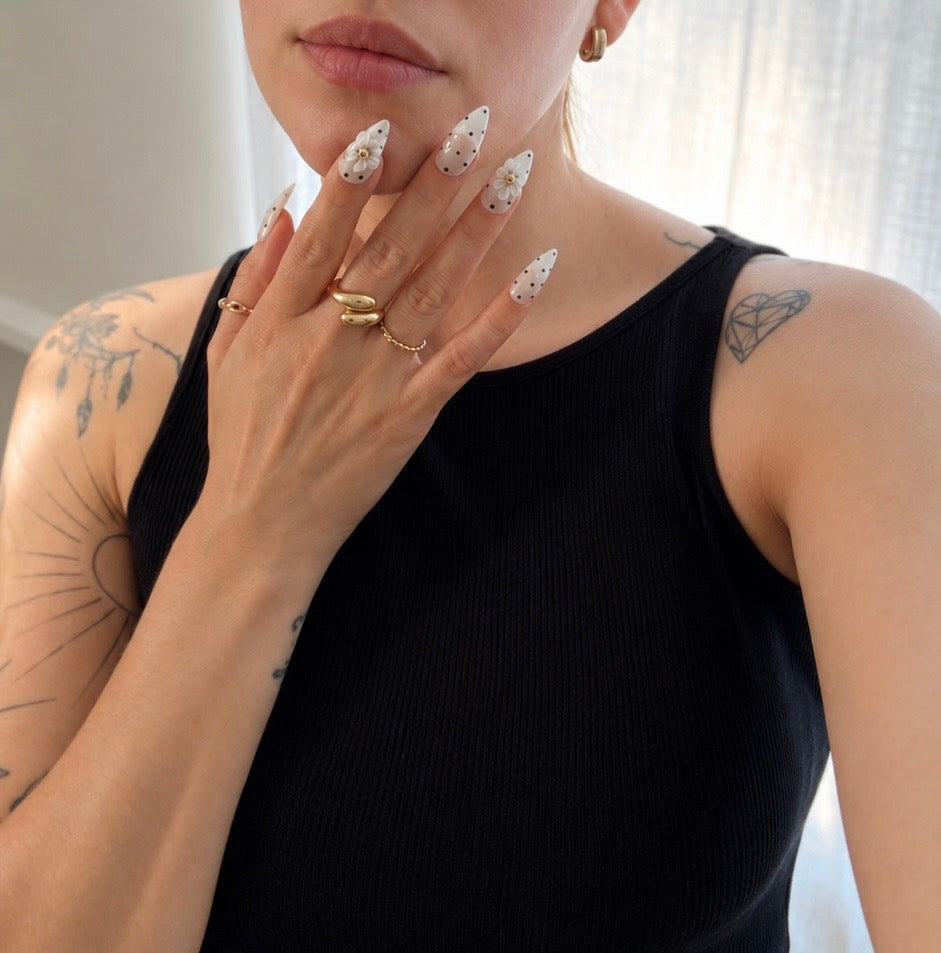   Woman wearing Daisy Noir handmade gel press-on nails.