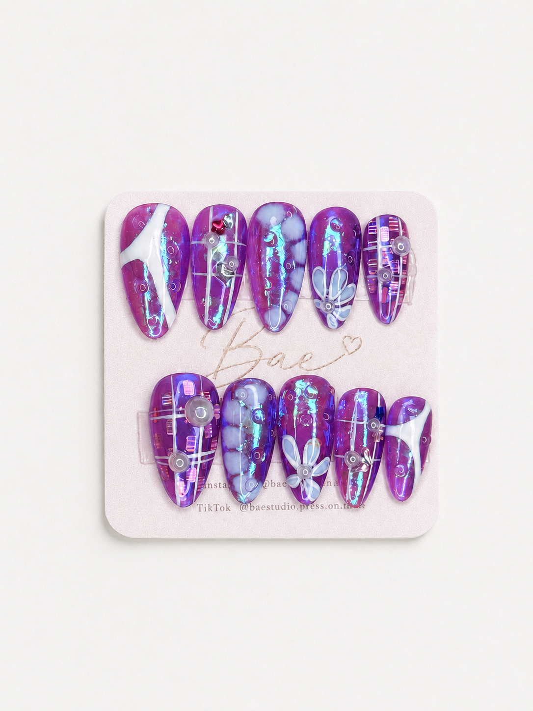 Violet Reverie purple iridescent handmade press-on nails with floral art and crystal details worn on hand