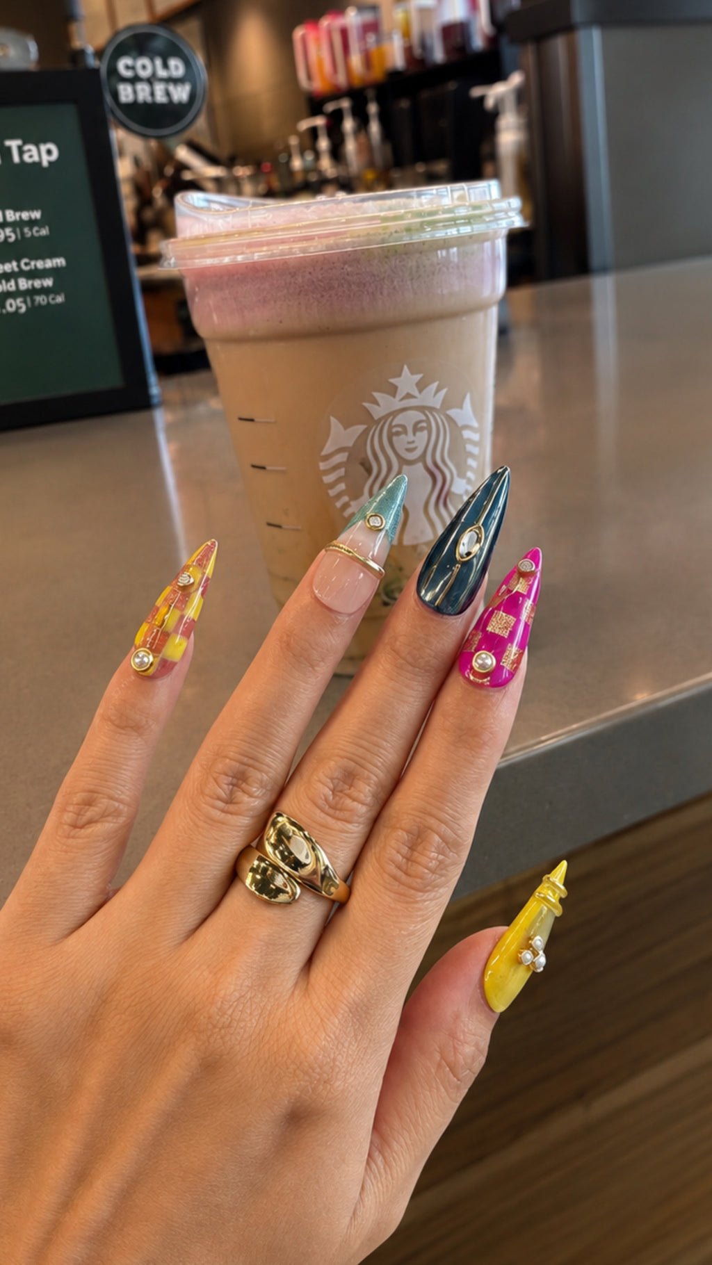 Fashion-inspired luxury press-on nails styled in a modern lifestyle setting with colorful artistic nail designs.