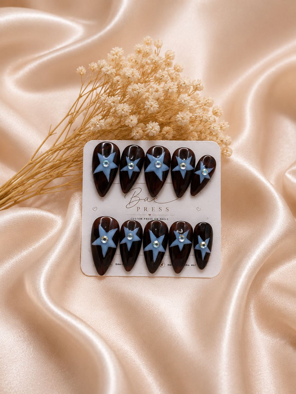 Starlight Tortoise press-on nails with tortoise shell pattern and blue star accents