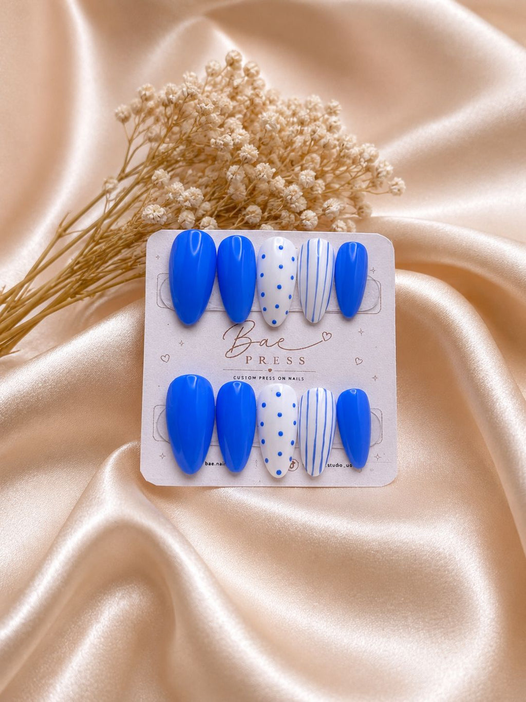 Cobalt Charm blue press-on nails with polka dot and striped accents