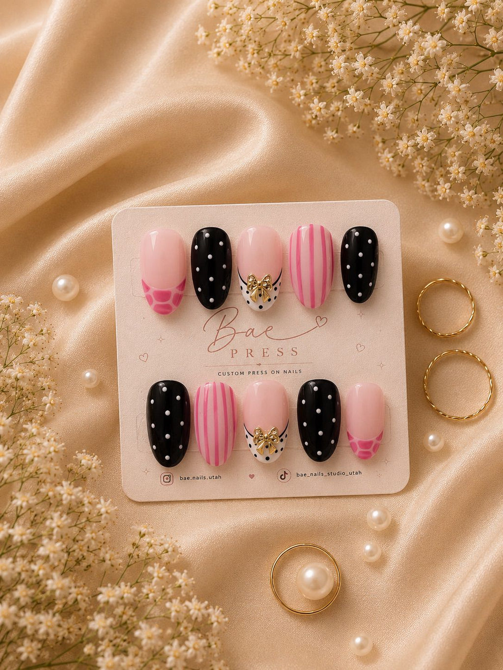 Pink Soirée luxury press-on nails with hand-painted stripes and gold bow charms